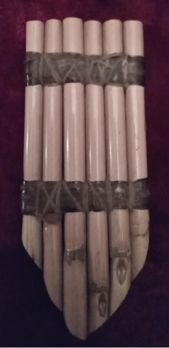 Close-up photograph of a soinari: six slender pipes of different lengths, bound side by side into a single row.